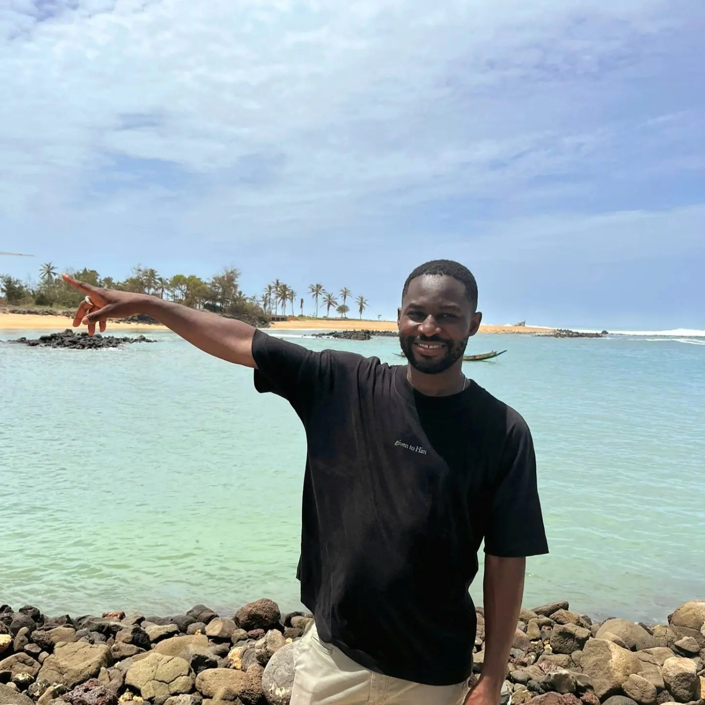 Ehonam Hamenou on the coast of Senegal, pointing toward the horizon